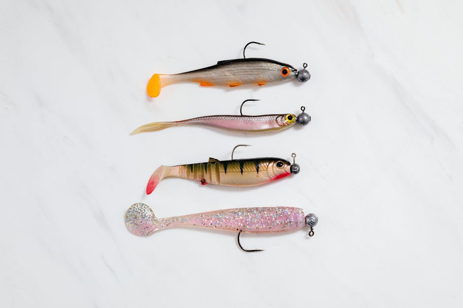 Soft plastic fishing baits including worms, grubs, and craws on a tackle table