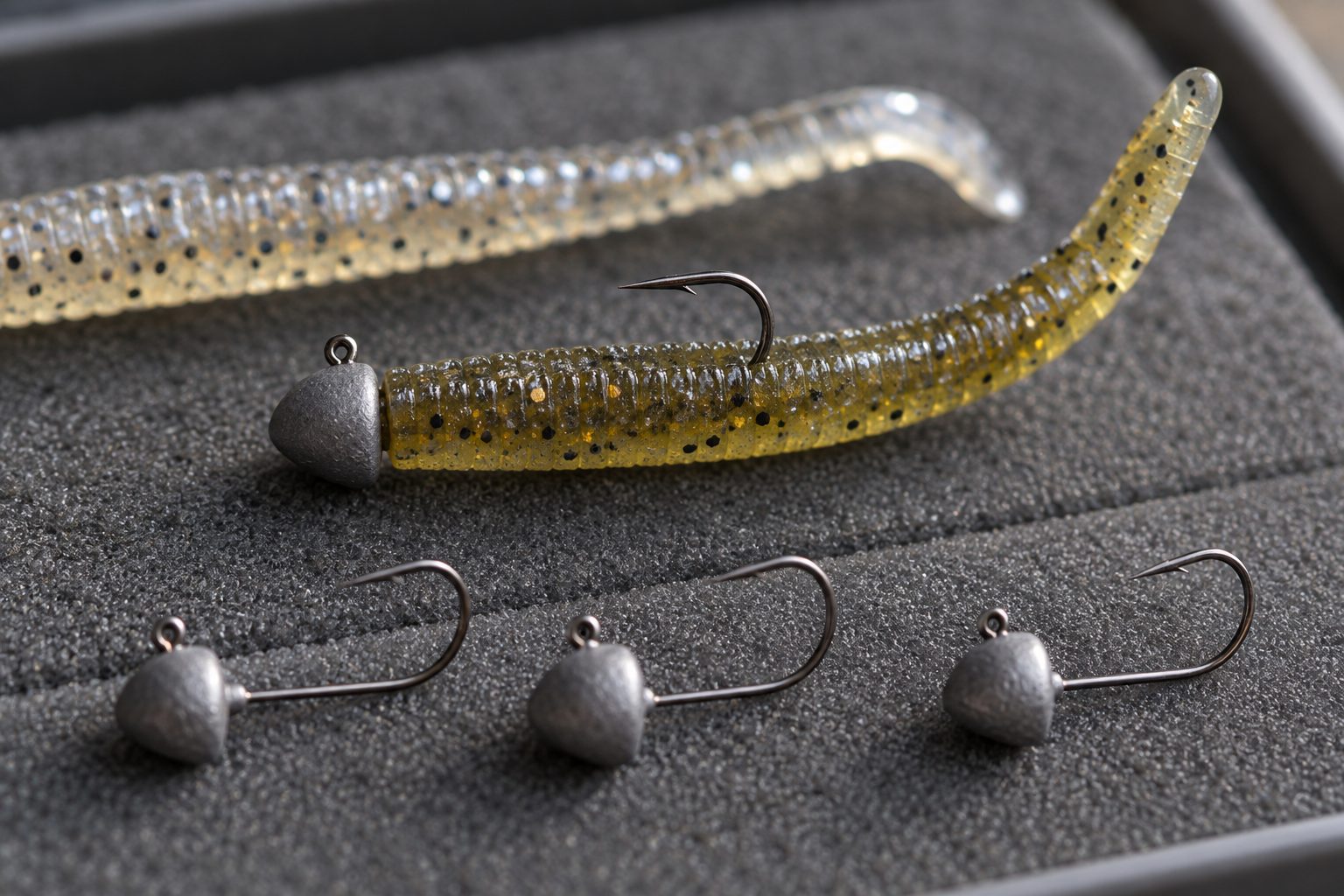 Close-up of mushroom jig heads and short buoyant soft plastics on a tackle tray